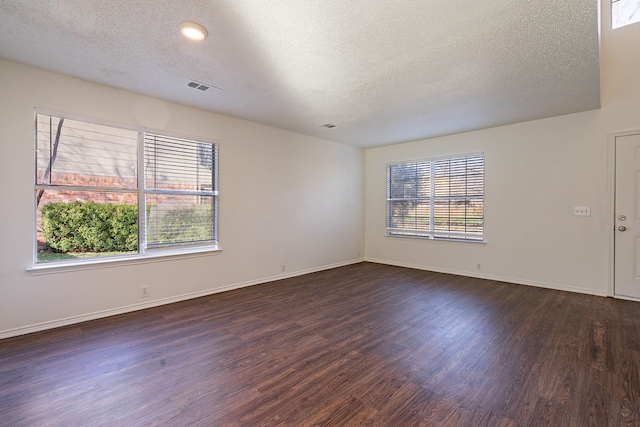 spare room with dark wood-type flooring and a textured ceiling