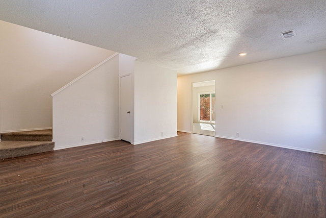 unfurnished living room with dark wood-type flooring and a textured ceiling