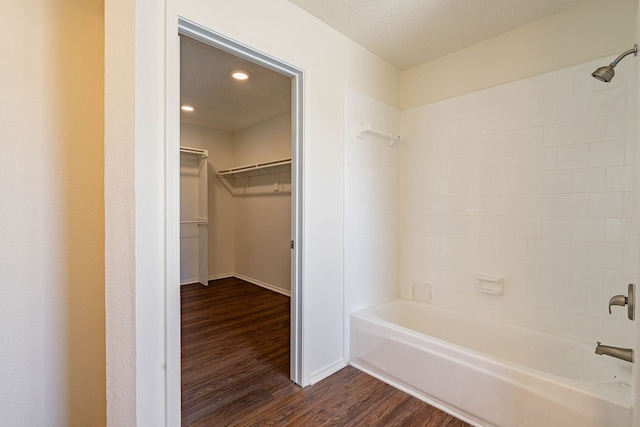 bathroom featuring shower / tub combination, wood-type flooring, and a textured ceiling