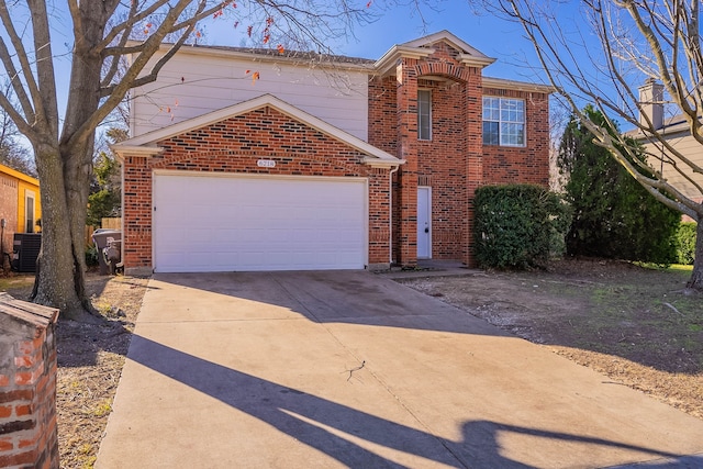 traditional-style home featuring a garage, cooling unit, concrete driveway, and brick siding