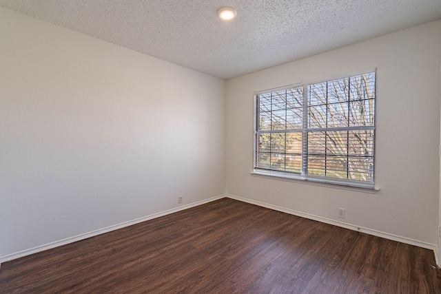 empty room featuring dark hardwood / wood-style floors and a textured ceiling