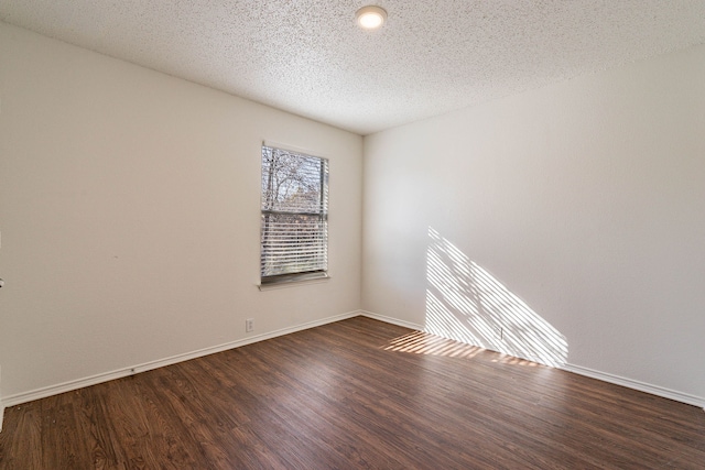 empty room featuring dark hardwood / wood-style flooring and a textured ceiling