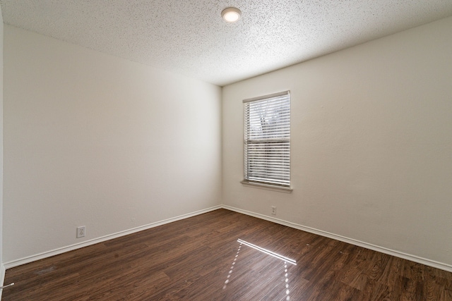 unfurnished room with dark wood-type flooring and a textured ceiling