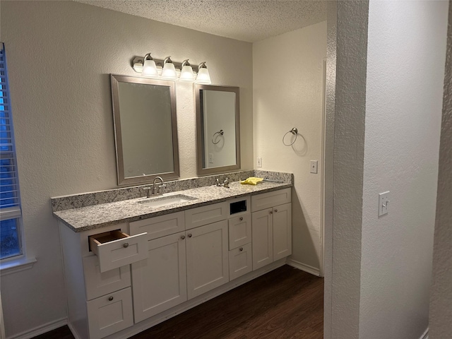 bathroom featuring vanity, wood-type flooring, and a textured ceiling