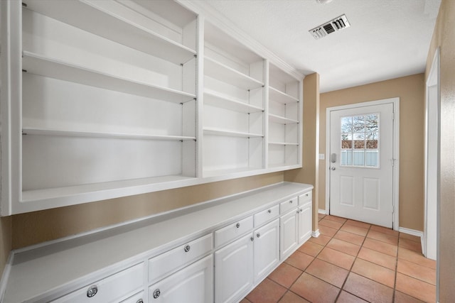 interior space featuring light tile patterned flooring and a textured ceiling