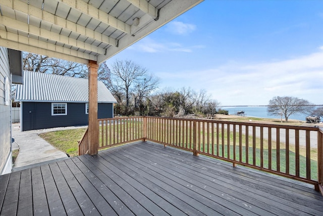 wooden deck with a water view and a yard