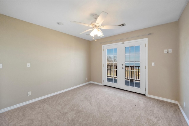 empty room featuring light carpet, ceiling fan, and french doors