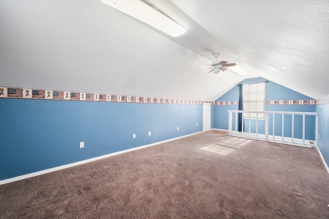 bonus room with vaulted ceiling, carpet floors, a textured ceiling, and ceiling fan