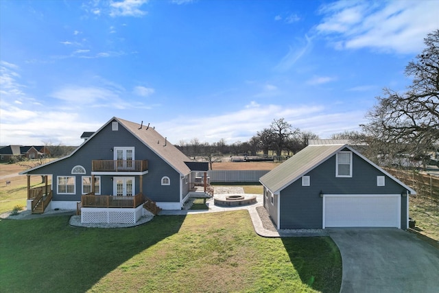 front of property featuring french doors, an outdoor fire pit, a front lawn, and a garage