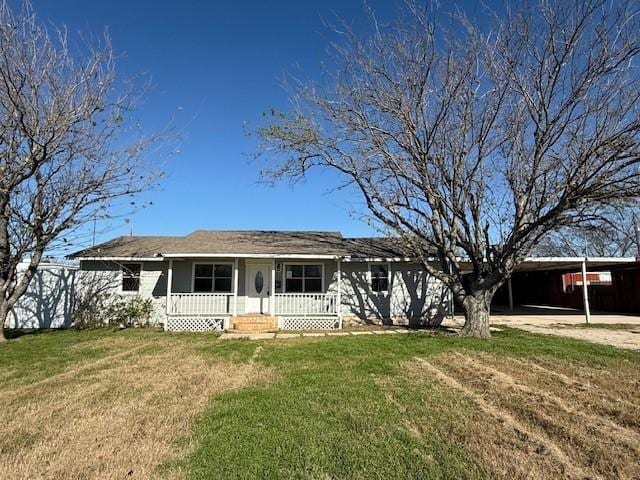 back of house featuring a carport, a yard, and covered porch