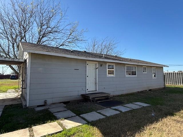 rear view of property featuring a lawn