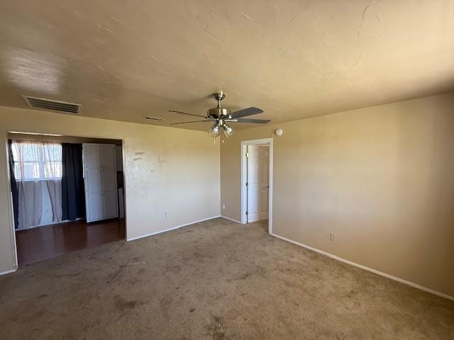 carpeted spare room with ceiling fan