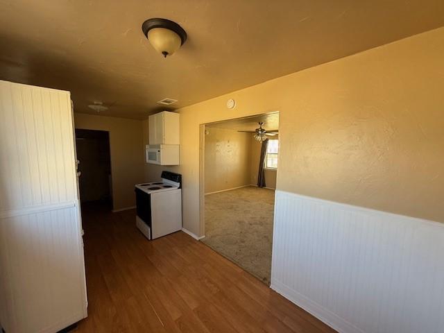 kitchen featuring white cabinets, hardwood / wood-style floors, white appliances, and ceiling fan