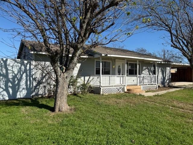 view of front of house with a front lawn, covered porch, and a carport