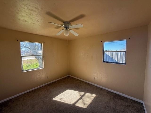 carpeted empty room with plenty of natural light and ceiling fan