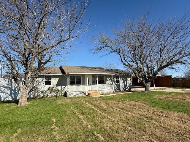 ranch-style house with a front yard and covered porch