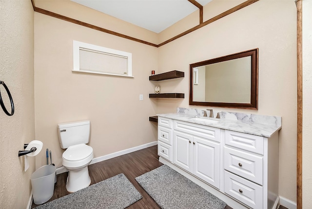 bathroom with toilet, vanity, and hardwood / wood-style flooring