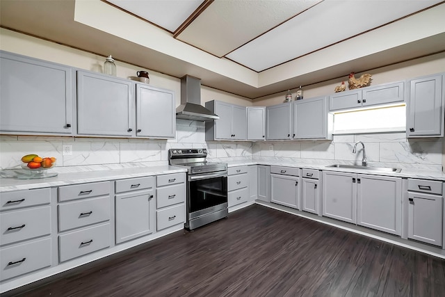 kitchen with dark wood-type flooring, sink, stainless steel electric range, and wall chimney range hood