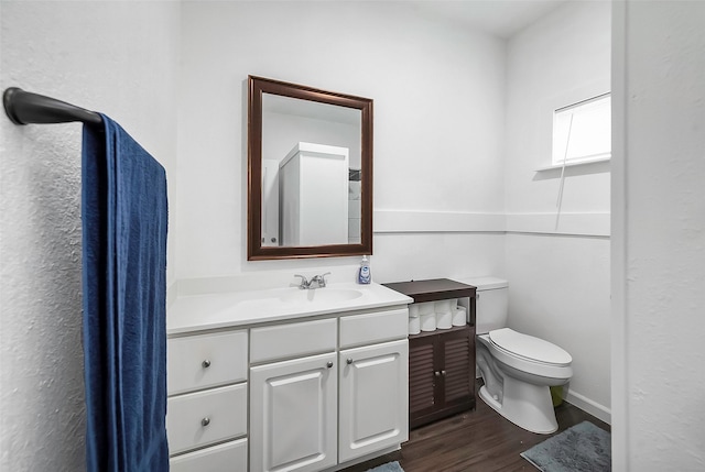 bathroom with hardwood / wood-style floors, vanity, and toilet