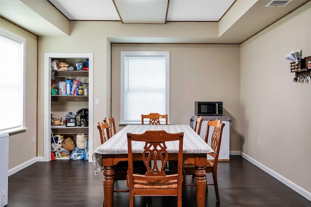 dining space featuring dark hardwood / wood-style floors and built in features