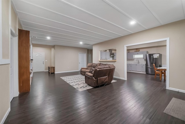 living room featuring sink and dark wood-type flooring