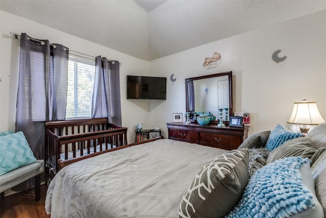 bedroom featuring a textured ceiling, vaulted ceiling, and hardwood / wood-style flooring