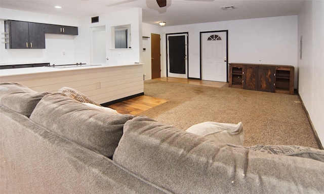 carpeted living room with ceiling fan