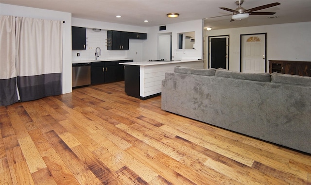 unfurnished living room featuring ceiling fan, sink, and light hardwood / wood-style flooring