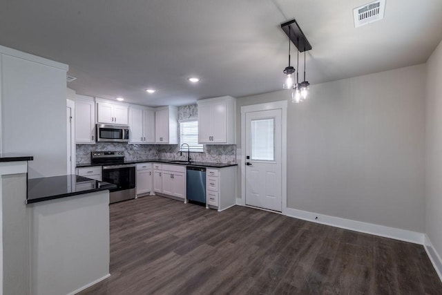 kitchen with sink, appliances with stainless steel finishes, decorative light fixtures, dark hardwood / wood-style flooring, and white cabinetry