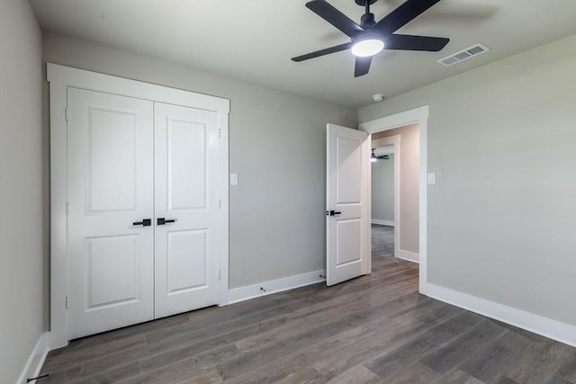 unfurnished bedroom featuring ceiling fan, dark hardwood / wood-style floors, and a closet