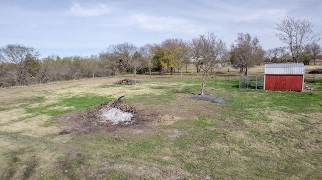 view of yard with a rural view and a storage shed