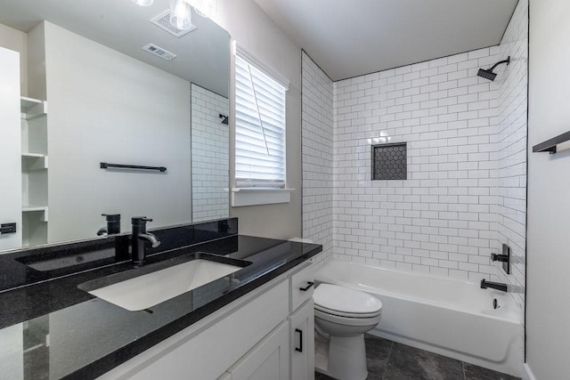 full bathroom with toilet, vanity, tile patterned floors, and tiled shower / bath