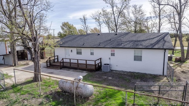 back of property with central AC unit and a deck