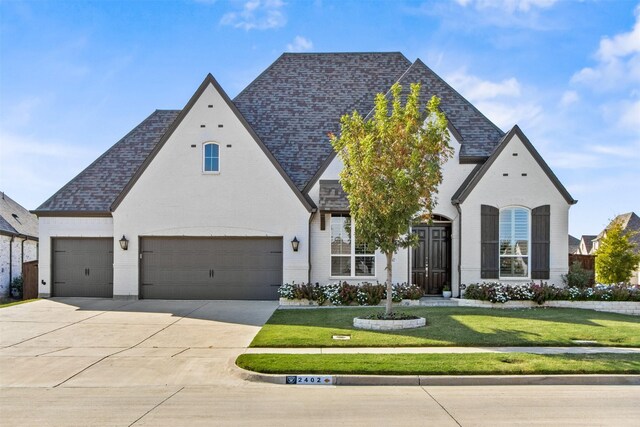 french provincial home featuring a garage and a front lawn