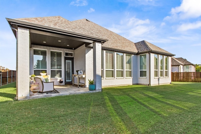 rear view of property with a yard and a patio area