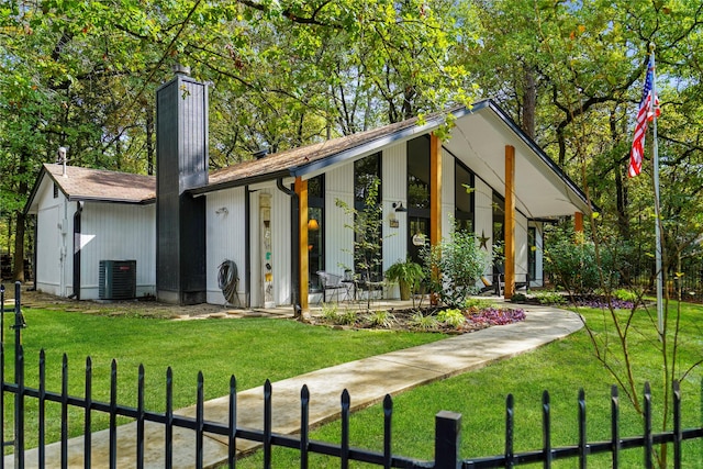 view of front of property featuring central AC unit and a front yard