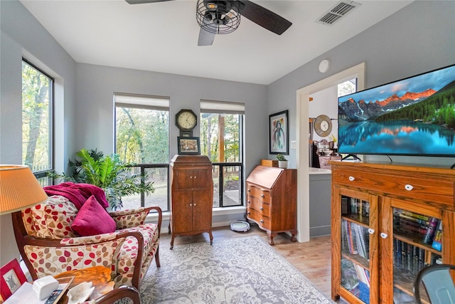 sitting room with ceiling fan and light wood-type flooring