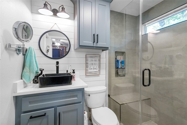 bathroom with vanity, toilet, and a shower with door