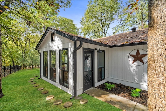 view of outdoor structure featuring a sunroom and a yard