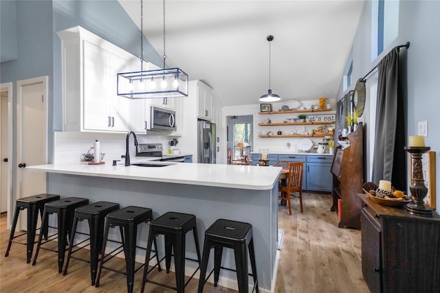 kitchen featuring backsplash, kitchen peninsula, white cabinets, and a kitchen breakfast bar