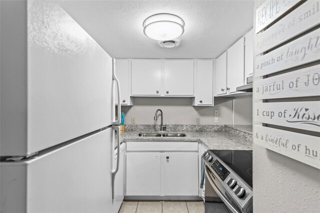 kitchen with a textured ceiling, sink, electric range, white refrigerator, and white cabinets