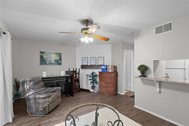 sitting room with dark hardwood / wood-style floors, ceiling fan, and sink