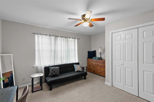 sitting room with ceiling fan and light colored carpet