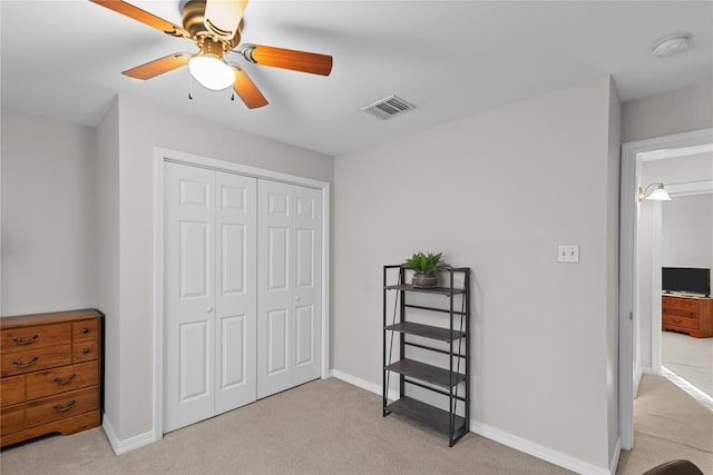 carpeted bedroom featuring a closet and ceiling fan