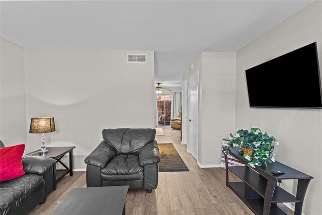 living room with hardwood / wood-style flooring and ceiling fan