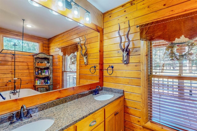 bathroom featuring vanity, a tub to relax in, and wooden walls