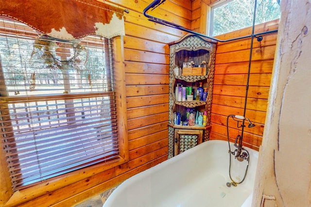 bathroom with a bathing tub and wood walls