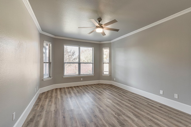 empty room with a textured ceiling, hardwood / wood-style flooring, ceiling fan, and crown molding