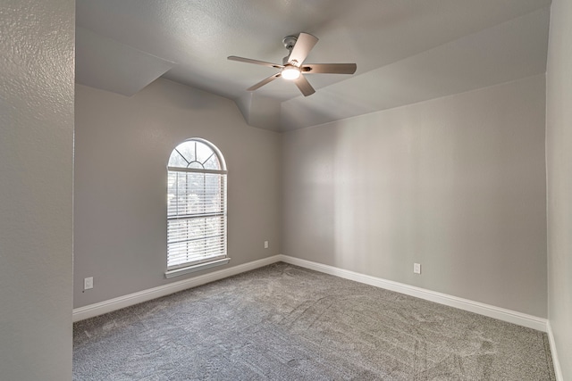 carpeted empty room featuring ceiling fan and vaulted ceiling