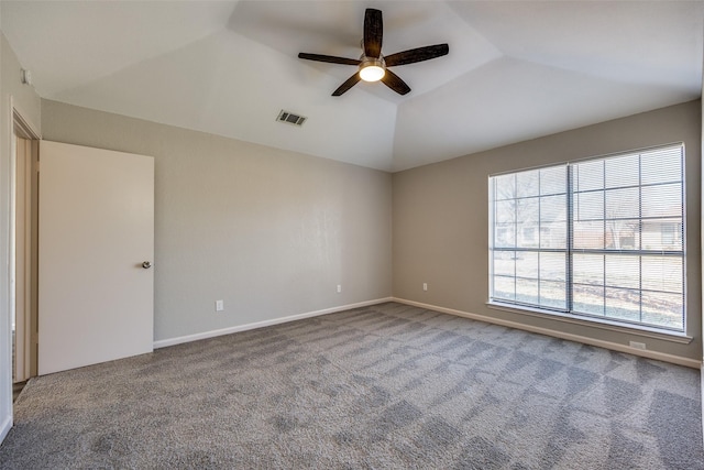 spare room featuring a tray ceiling, ceiling fan, carpet flooring, and vaulted ceiling